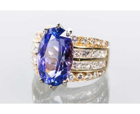 TANZANITE AND DIAMOND DRESS RING
set with a large oval tanzanite of approximately 7.46 carats, flanked by two outer rows of b