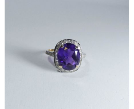 Large and impressive amethyst and diamond dress ring, claw set with a large oval amethyst in a 9ct white gold setting with pa