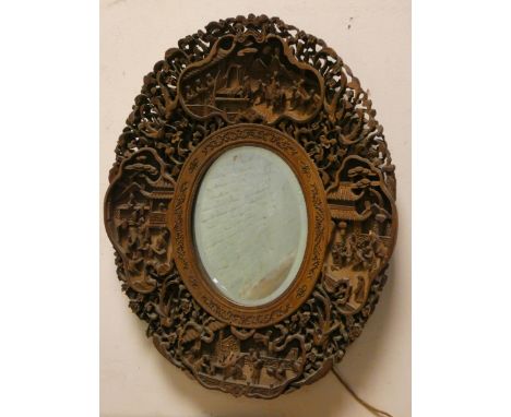 A Chinese carved hardwood oval bevelled wall mirror, overall height 17" 