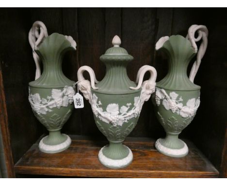 A three piece green Jasper mantelpiece garniture comprising a pair of ewer's and a lidded Neo classical vase with rams head h