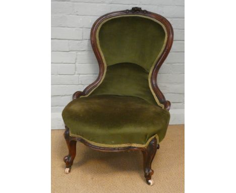 A late Victorian mahogany framed balloon back nursing chair upholstered in green velvet 