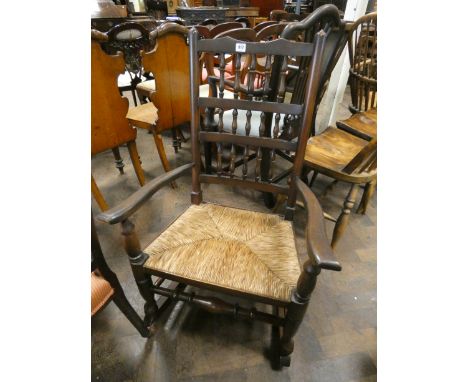 A Lancashire style oak spindle back rocking elbow chair with rush seat 