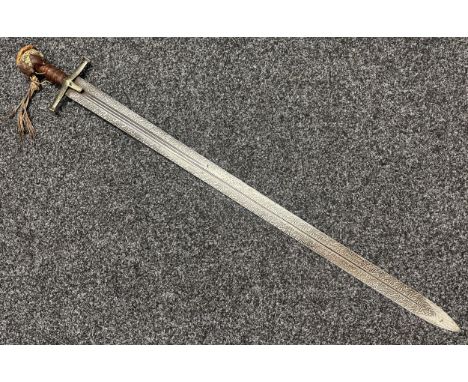 Sudanese Kaskara Sword with double edged fullered patterned blade 950mm in length. Brass crossguard. Leather bound grip and p