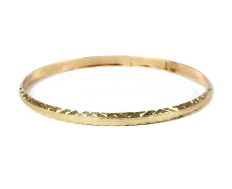 A gold bangle, with bright cut decoration, marked 14K, 7.75gCondition report: Minor surface marks.