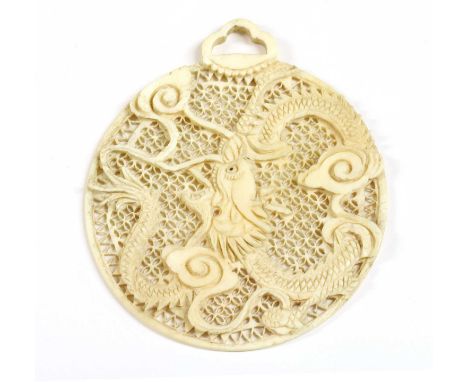 A carved pierced ivory pendant, a carved Chinese dragon to a pierced ground, with carved pendant bale, 81 x 71mm, 15.94gCondi