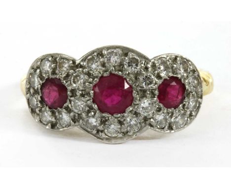 An 18ct gold ruby and diamond triple cluster ring, a graduated row of circular mixed cut rubies, to surround of brilliant cut