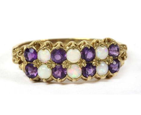 A 9ct gold opal and amethyst ring, with alternating round cabochon opals, two possibly later replacements, and circular mixed