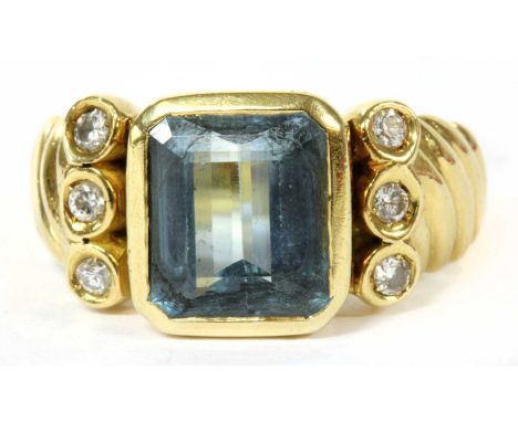 A gold aquamarine and diamond ring, an emerald cut aquamarine, rub set, with a column of brilliant cut diamonds, spitch set a