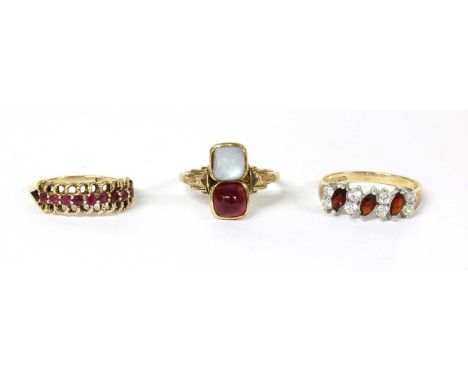 A 9ct gold ruby ring, with a row of circular mixed cut rubies, one later paste replacement, claw set, to coiled twisted wire 
