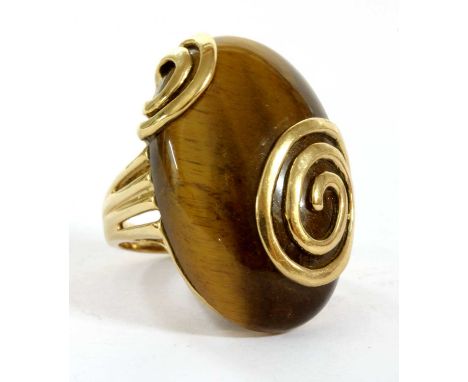 A 9ct gold tiger's eye ring, an oval cabochon tiger's eye, approximately 30 x 18mm, set with gold spirals, to split shoulders