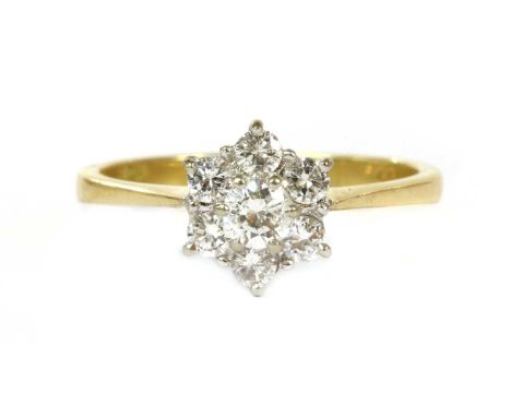 An 18ct gold diamond cluster ring, seven brilliant cut diamonds, claw set in white gold to a wire gallery, with yellow gold s