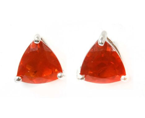 A pair of white gold fire opal stud earrings, a triangular mixed cut fire opal, claw set to threaded post and screw fittings,