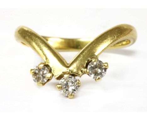 An 18ct gold three stone diamond ring, with brilliant cut diamonds claw set to the wishbone shaped head, to plain polished sh