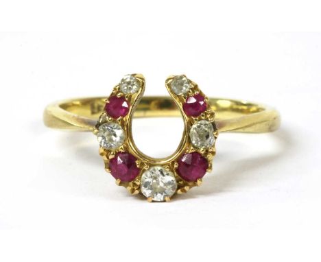 A gold diamond and ruby horseshoe ring, a row of graduated alternating old brilliant cut diamonds and mixed cut rubies, claw 