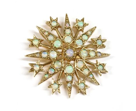 A 9ct gold opal star pendant, a round cabochon opal in clawed collet to the centre, to eight rayed star grain set with gradua