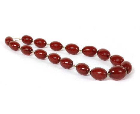 A single row graduated oval cherry coloured Bakelite bead necklace, with swirls, the largest bead approximately 23 x 17mm, wi