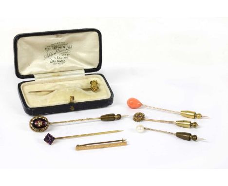 A collection of stick pins, five tested as approximately 9ct gold, with a balloon shaped carved coral finial, a pearl finial,