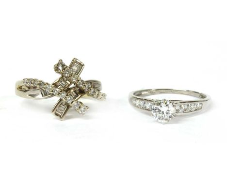 A white gold diamond crossover dress ring, with two strands grain set with brilliant cut diamonds, and two strands channel se