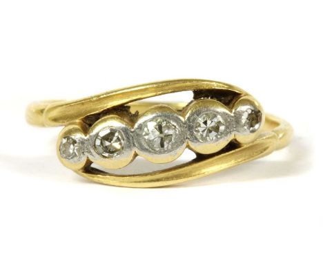 A gold five stone diamond crossover ring, a row of graduated brilliant and eight cut diamonds, rubover set to plain collets f