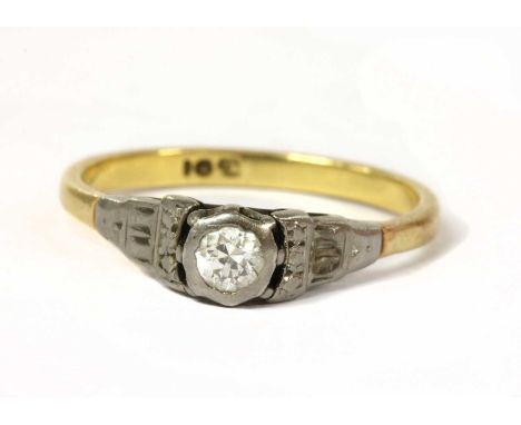 A gold single stone diamond ring, a brilliant cut diamond, grain set to a white gold illusion collet, to stepped shoulders an