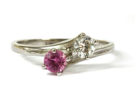 An 18ct white gold diamond and pink sapphire crossover ring, a brilliant cut diamond with a stated weight of 0.24ct, and a ci