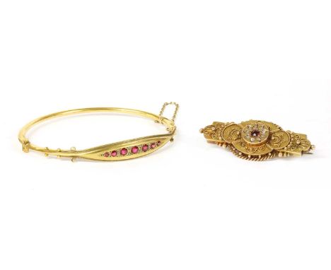 A 15ct gold ruby and diamond brooch, a Swiss cut ruby with surround of rose cut diamonds, grain set to the circular boss, to 