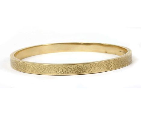 A 9ct gold hollow bangle, by Henry Griffiths &amp; Sons, with engine turned decoration, Chester 1928, 9.64gCondition report: 