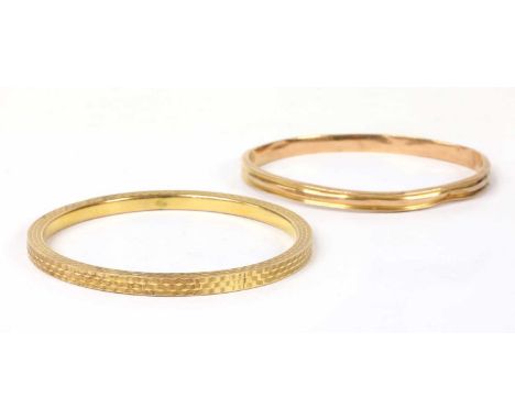 A 9ct gold hollow flat section bangle, with engine turned decoration, Birmingham 1925, together with a 9ct gold hollow bangle