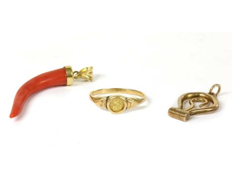 A gold coral cornicello pendant, the carved coral cap set to a fluted articulated bale, marked 750, Italian official national