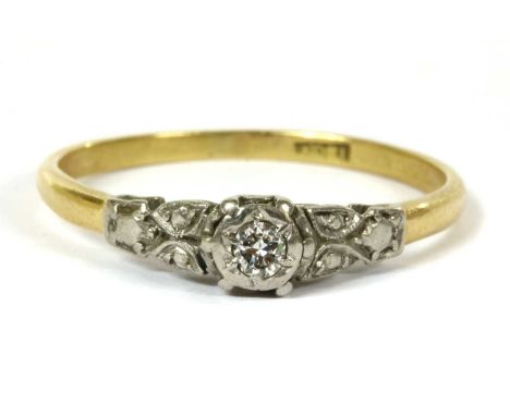 A gold single stone diamond ring, a brilliant cut diamond grain set to an illusion collet, with foliate shoulders and a D sec