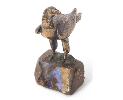 A heavy cast paperweight model of an eagle mounted on a rock base highlighted with polished opal scenes, 14cm tall