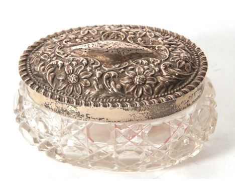 An Edwardian cut glass trinket box of oval form with hallmarked silver pull off embossed lid, Birmingham 1905, makers mark fo