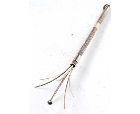 An Art Deco swizzle stick with retractable mechanism and engine turned barrel, marked sterling silver, 8cm long