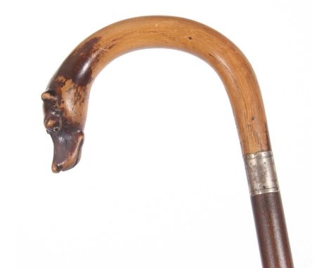 Vintage walking stick, the curved handle with a dogs head having inset glass eyes and a metal band, a cane handle
