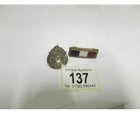 A silver fob and an enamel bar