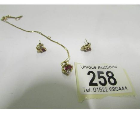A 14ct gold chain and pendant set diamonds and ruby with a matching pair of earrings