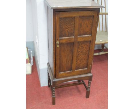 An Oak Smokers Cabinet, with panelled door fitted interior on bobbin supports, united by 'H' stretcher 41.5cm wide.