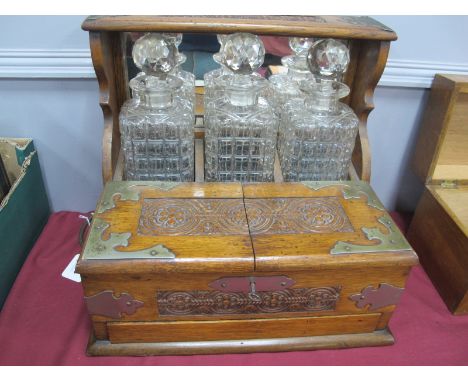 A Late XIX Century Oak Tantalus, with flower head carving to top, fascia and lift up door. Nickel mounts, fall handles, secre