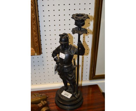 A cast iron figural candlestick as a Spanish conquistador, the candlestick as a pike staff, black socle base