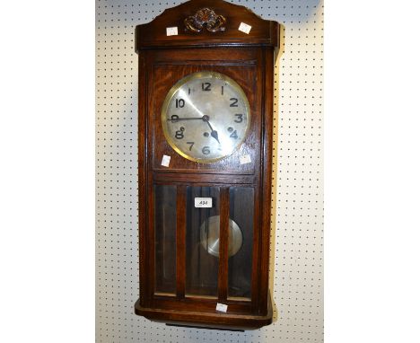 A 1930's oak wall clock; a 1930s oak mantel clock (2)