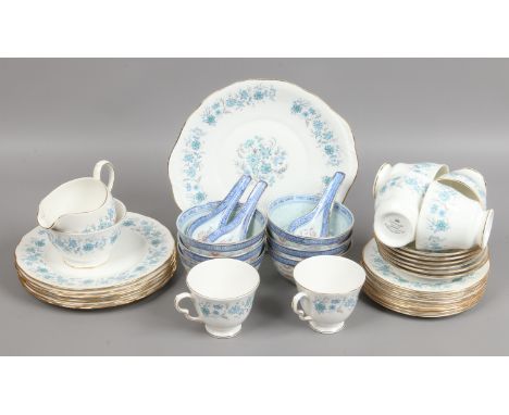 A Colclough china six place tea service decorated with flowers along with six rice bowls and spoons.