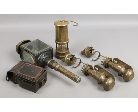 A group of vintage lanterns including two GWR examples, along with a brass miners lamp.