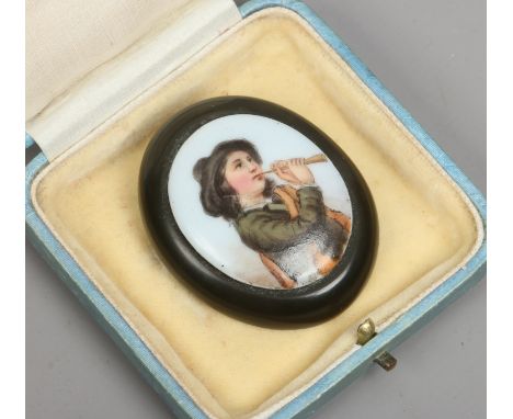 A hand painted portrait miniature on porcelain brooch of a young piper boy.