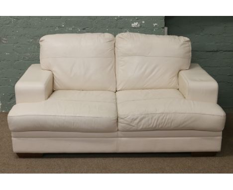 A cream leather two seat sofa.