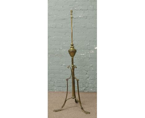 A Victorian brass rise and fall standard lamp raised on scroll supports.