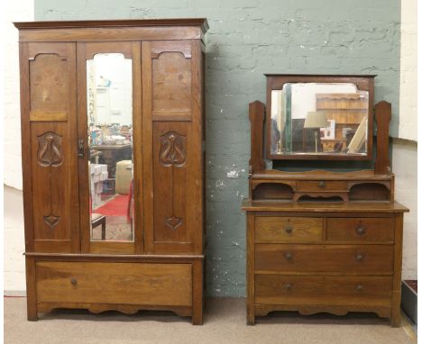 An Art Nouveau carved oak mirror front wardrobe and matching dressing table.