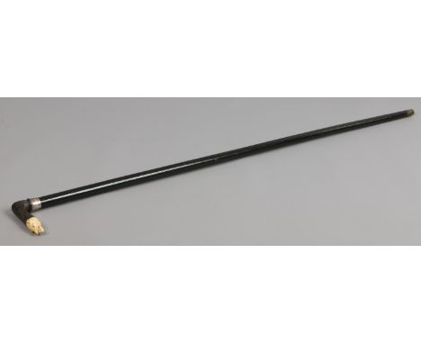 An ebonized walking stick with carved wood and ivory handle formed as a wolf's head and silver collar, assayed London 1903.