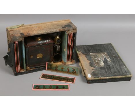 A childs German boxed tin plate magic lantern with slides, lenses and glass chiming.