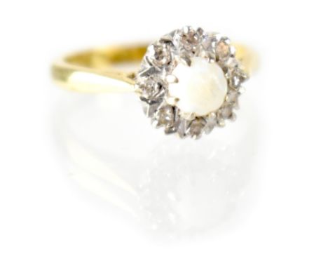 An 18ct gold ring with white opal within a border of tiny diamonds, size K, approx 3.6g.