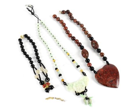 Three Chinese necklaces to include a green jade floral carved necklace, a black and brown necklace with carved beads and larg